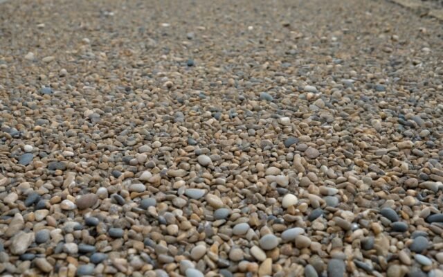 Close up of exposed aggregate concrete with tan and gray pebbles in Fayetteville, NC